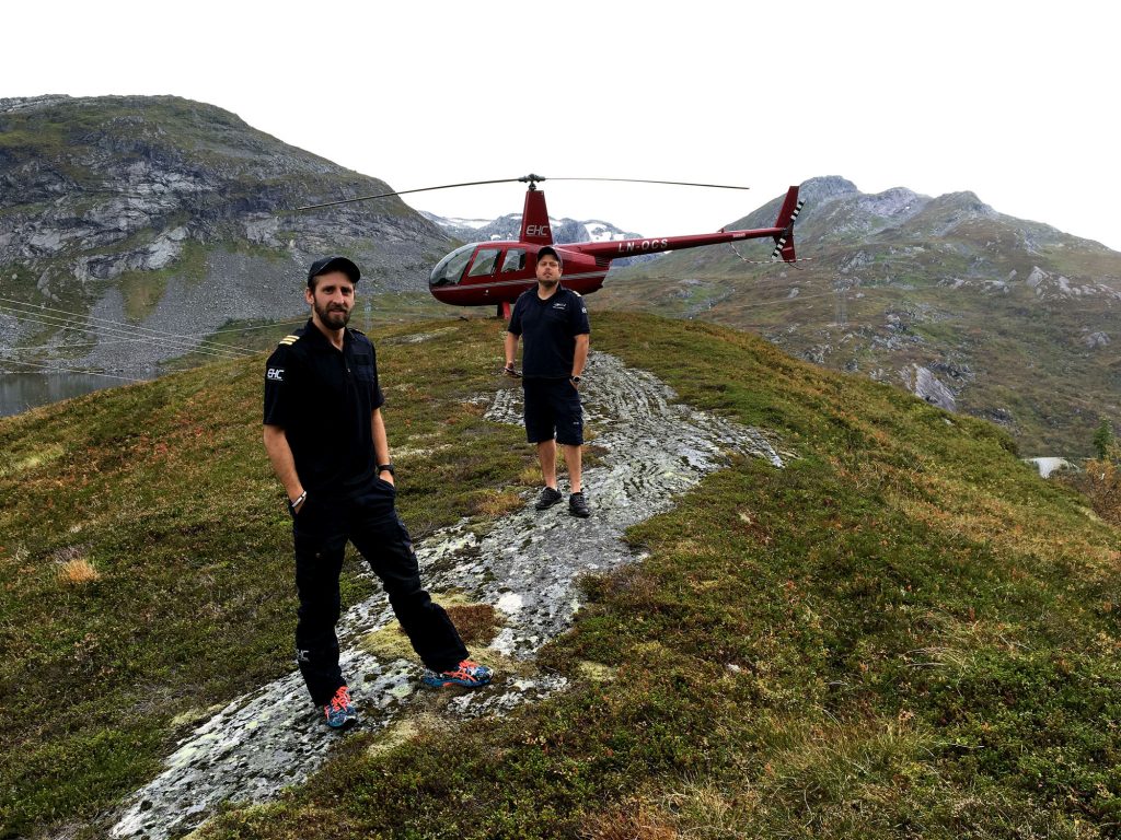 Som helikopterpilot har du varierte arbeidsdager, med nye utsikter hver eneste dag. Her er to av våre piloter avbildet på tur i Sogn og Fjordane, foran en av våre Robinson R44. Denne typen helikopter brukes ofte til sightseeing og persontransport.